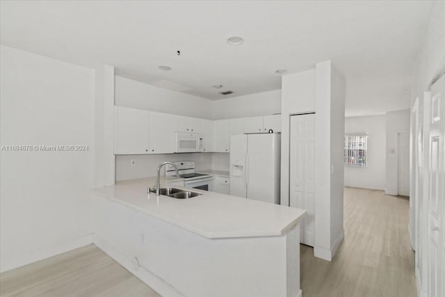 kitchen featuring white appliances, sink, kitchen peninsula, white cabinets, and light hardwood / wood-style flooring