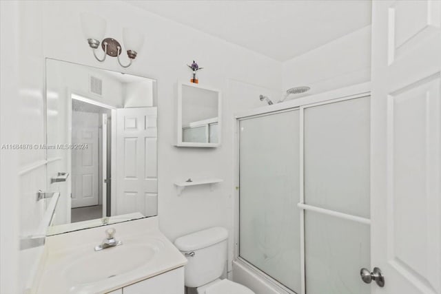 full bathroom featuring vanity, bath / shower combo with glass door, and toilet