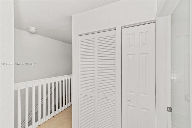 hallway featuring light colored carpet