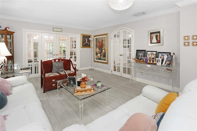 living room featuring french doors, ornamental molding, and light wood-type flooring