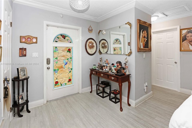 entryway featuring ornamental molding, a textured ceiling, and light wood-type flooring