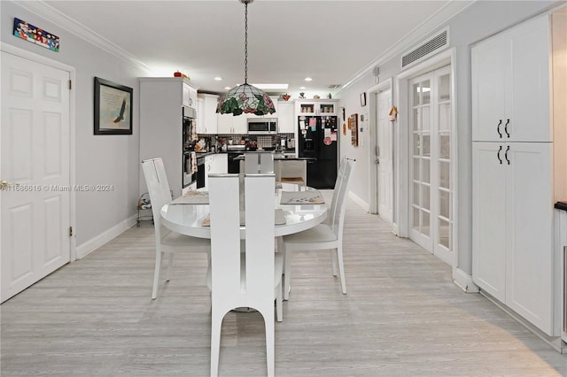 dining room featuring ornamental molding and light wood-type flooring