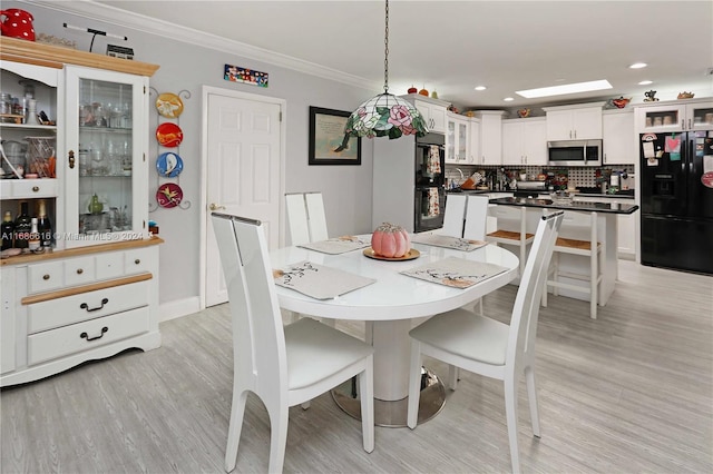 dining room featuring crown molding and light hardwood / wood-style flooring