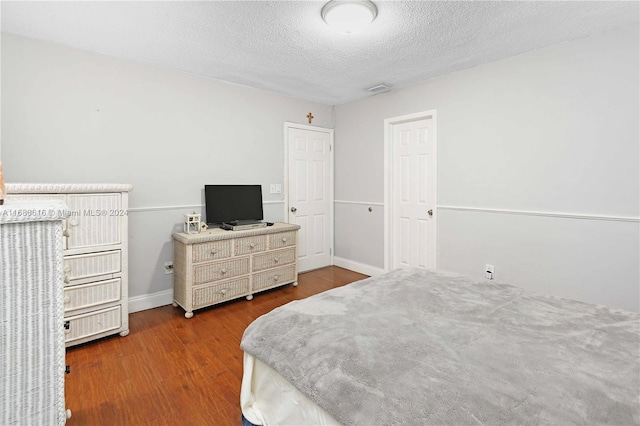 bedroom with hardwood / wood-style floors and a textured ceiling