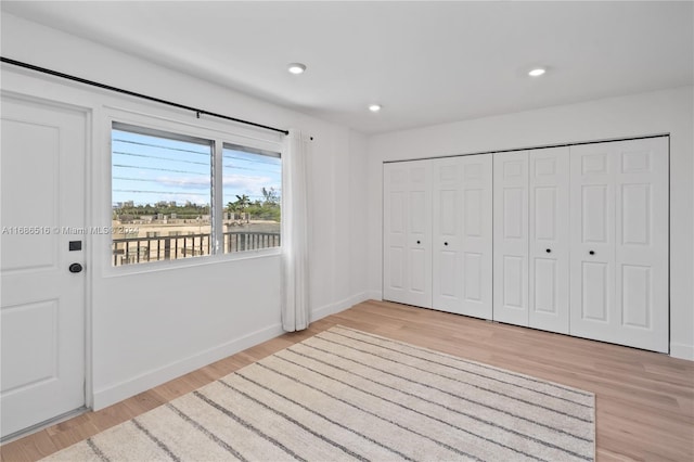 unfurnished bedroom with a closet and light hardwood / wood-style floors