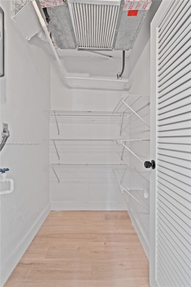 spacious closet with hardwood / wood-style flooring