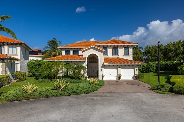 mediterranean / spanish-style house featuring a front yard and a garage