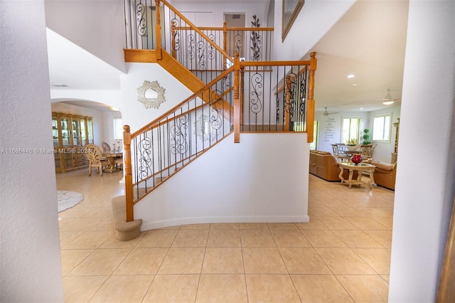 staircase featuring tile patterned floors and a high ceiling