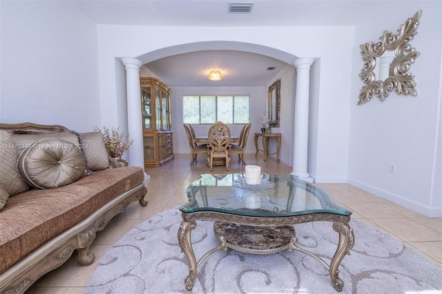 living room with ornate columns and light tile patterned floors