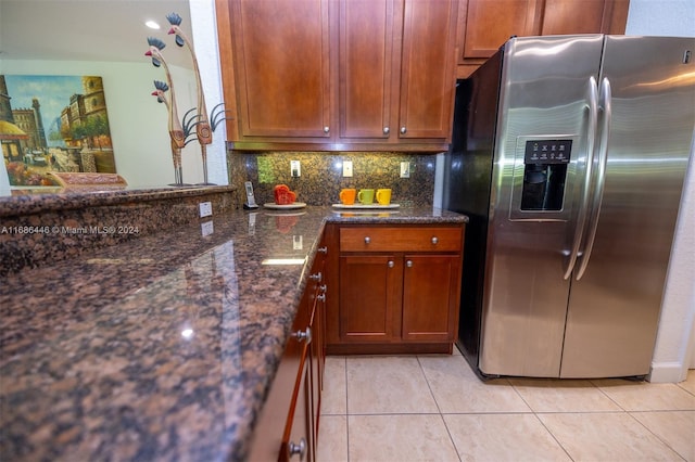 kitchen with tasteful backsplash, stainless steel fridge with ice dispenser, dark stone counters, and light tile patterned flooring