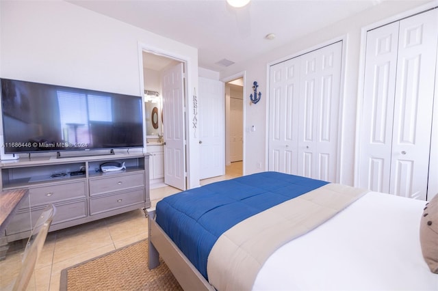 bedroom featuring multiple closets and light tile patterned floors