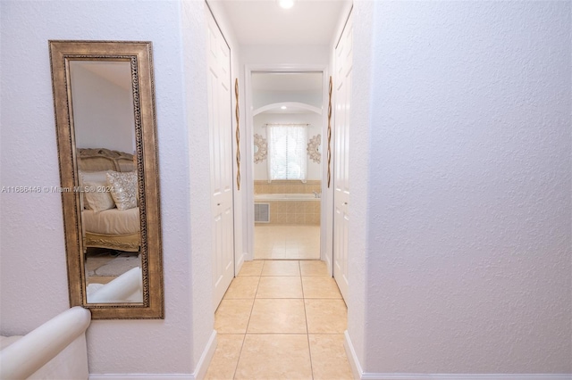 hall featuring light tile patterned flooring