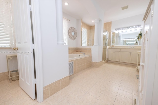 bathroom featuring vanity, decorative columns, tile patterned flooring, and tiled tub