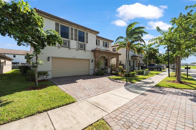 mediterranean / spanish-style house with a garage and a front lawn