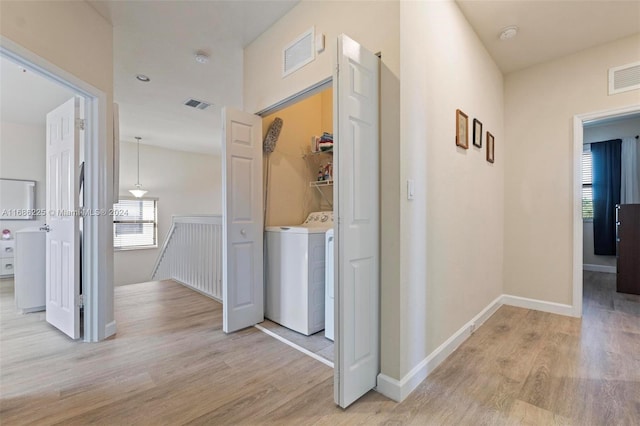 hallway featuring washer / clothes dryer and light hardwood / wood-style flooring