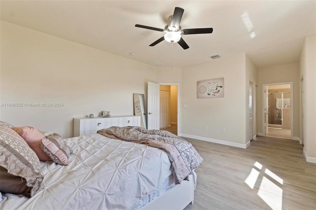 bedroom with ensuite bath, ceiling fan, and light hardwood / wood-style floors