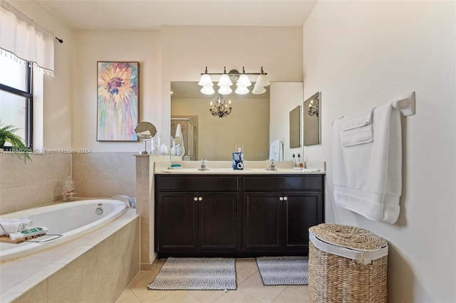 bathroom with vanity, an inviting chandelier, tile patterned floors, and tiled tub