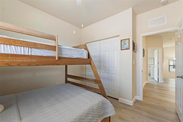 bedroom featuring ceiling fan, a closet, and light hardwood / wood-style floors