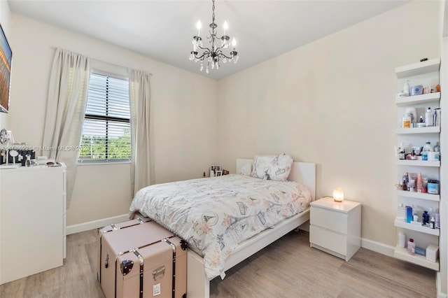 bedroom with light hardwood / wood-style flooring and a notable chandelier