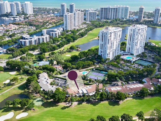 aerial view featuring a water view, view of golf course, and a city view