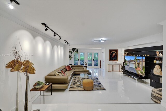 tiled living room with french doors, rail lighting, and crown molding