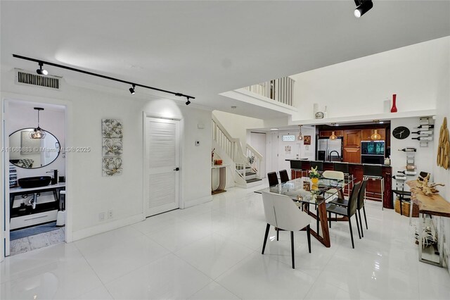 dining space with light tile patterned floors and track lighting