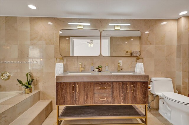 bathroom featuring vanity, toilet, tile walls, and ceiling fan