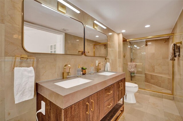 bathroom with walk in shower, tile patterned floors, toilet, vanity, and tile walls