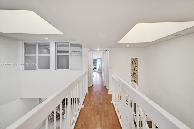 hallway featuring a skylight and hardwood / wood-style floors