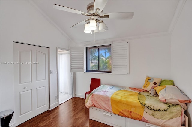 bedroom featuring ceiling fan, dark wood-type flooring, lofted ceiling, a closet, and ornamental molding