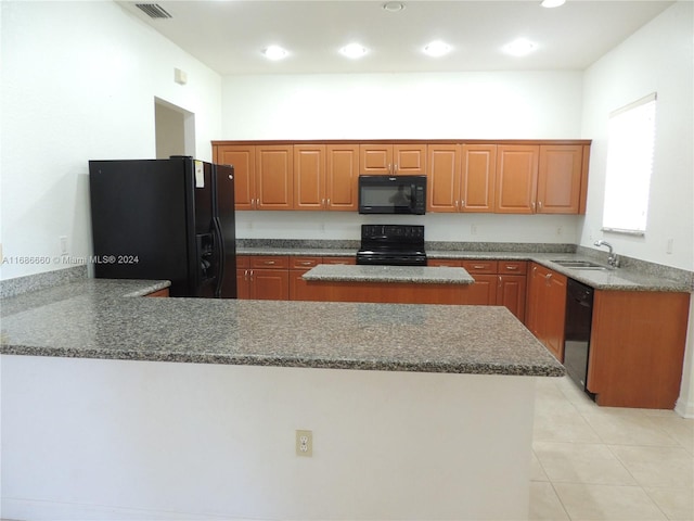 kitchen featuring sink, black appliances, kitchen peninsula, dark stone countertops, and a center island