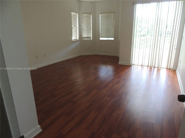 unfurnished room featuring dark wood-type flooring and ceiling fan