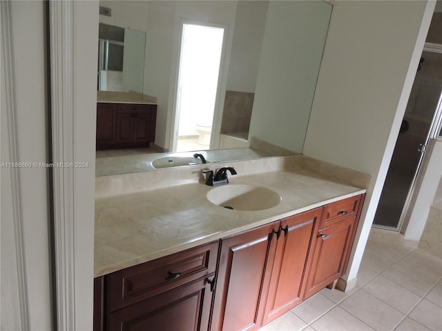 bathroom featuring a shower with shower door, vanity, tile patterned floors, and toilet