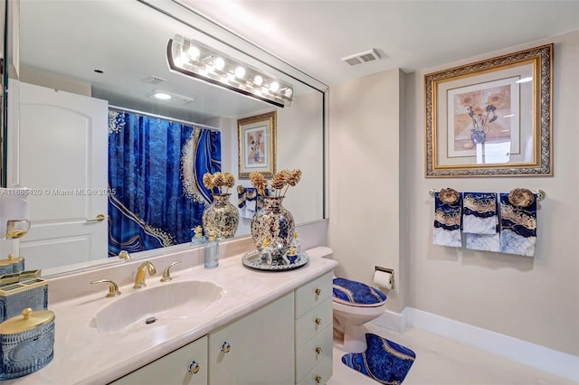 bathroom featuring vanity, toilet, and tile patterned flooring