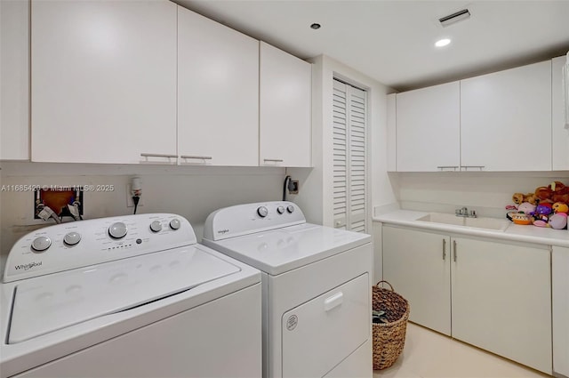 washroom with separate washer and dryer, sink, and cabinets