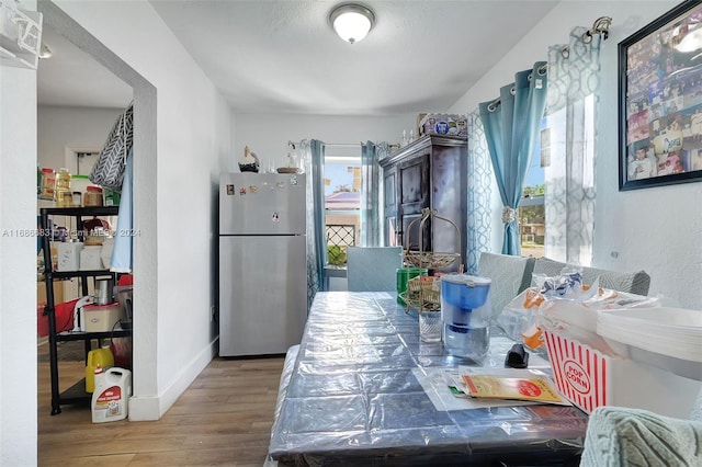 kitchen with wood-type flooring and stainless steel refrigerator