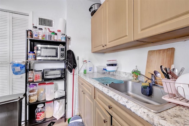 kitchen with light stone countertops and sink