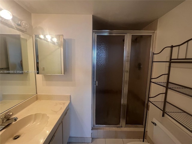 bathroom featuring walk in shower, vanity, and tile patterned flooring