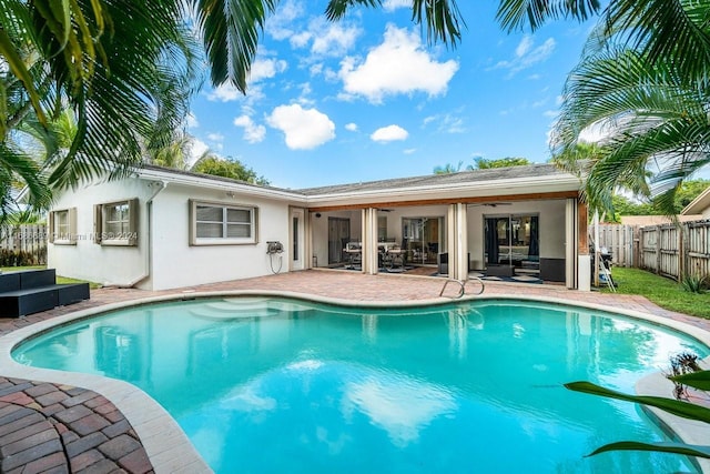 view of swimming pool featuring a patio, an outdoor hangout area, and ceiling fan