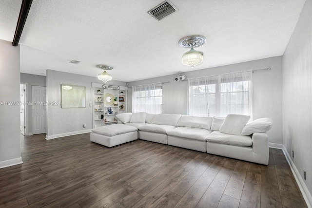 unfurnished living room featuring a textured ceiling and dark hardwood / wood-style flooring