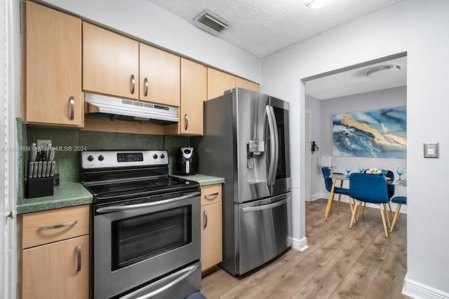 kitchen with decorative backsplash, light brown cabinetry, appliances with stainless steel finishes, a textured ceiling, and light hardwood / wood-style floors