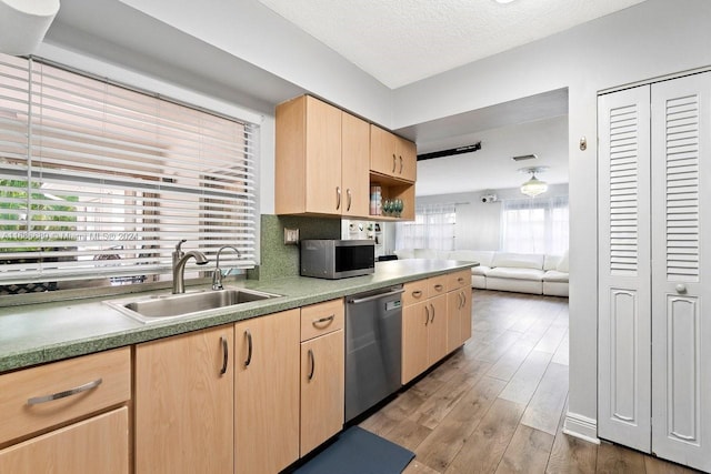 kitchen with appliances with stainless steel finishes, sink, a textured ceiling, hardwood / wood-style floors, and light brown cabinets