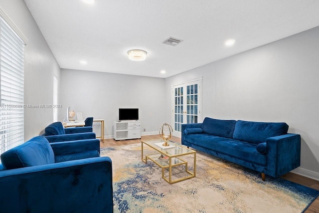 living room featuring a textured ceiling, hardwood / wood-style flooring, and a healthy amount of sunlight