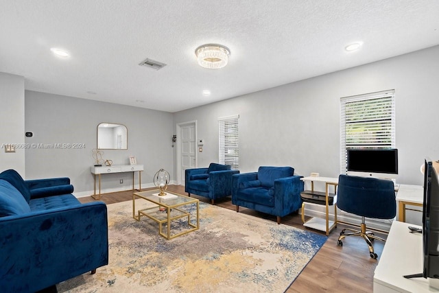 living room with hardwood / wood-style flooring and a textured ceiling