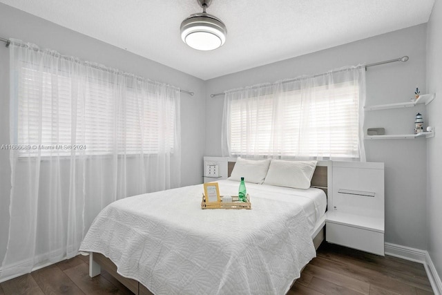 bedroom with dark hardwood / wood-style floors