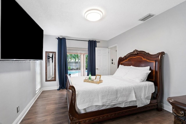 bedroom with a textured ceiling and dark hardwood / wood-style flooring