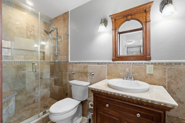 bathroom with vanity, toilet, tile walls, and an enclosed shower