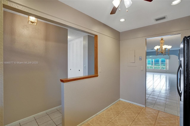 corridor featuring light tile patterned flooring and a chandelier