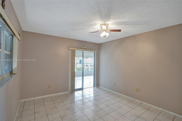 unfurnished room featuring ceiling fan, light tile patterned flooring, and a textured ceiling