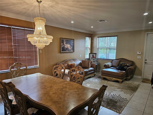 tiled dining area featuring crown molding and an inviting chandelier